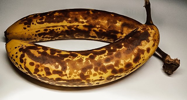 two overripe bananas with brown spotted peels