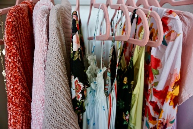 Closet with clothes hanging on pink velvet hangers