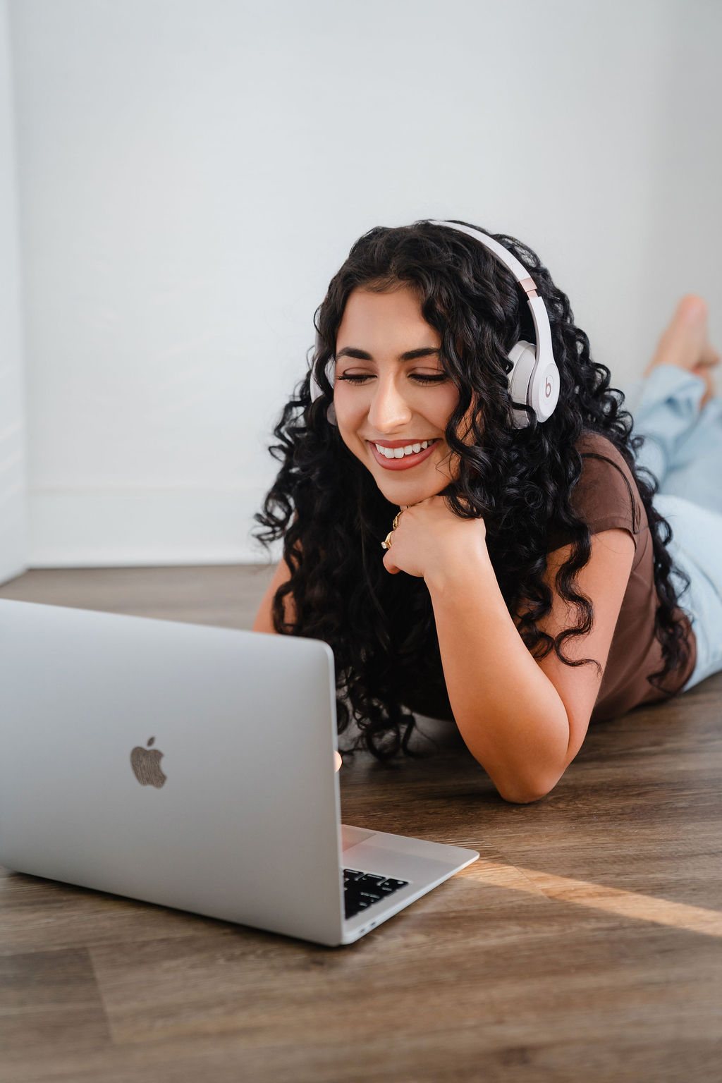 Girl wears pink beats headphones and works on a Macbook air laptop on the ground | Lifestyled By Sofia