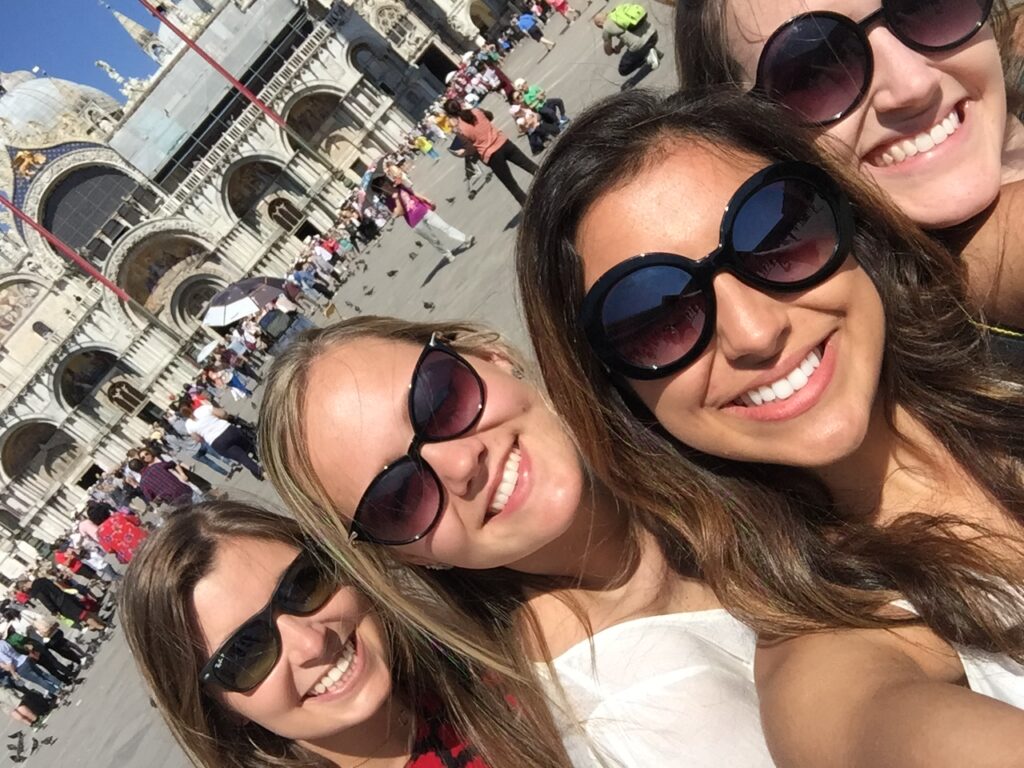 Group of four girls take a selfie in Venice in front of the Doges Palace