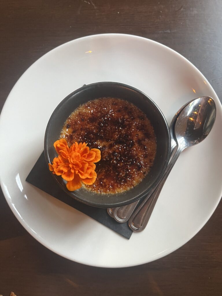 Plate holds a bowl of Honey Lavender Creme Brulee at The Burrow in East Hill Pensacola