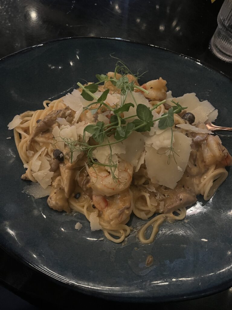 Blue plate holds a meal of Fedelini with Shrimp & Mushroom at Agapi Bistro in Pensacola FL