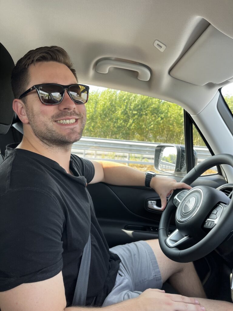 Man smiles from the drivers seat of a Jeep Renegade | two week itinerary in northern Italy by train and car
