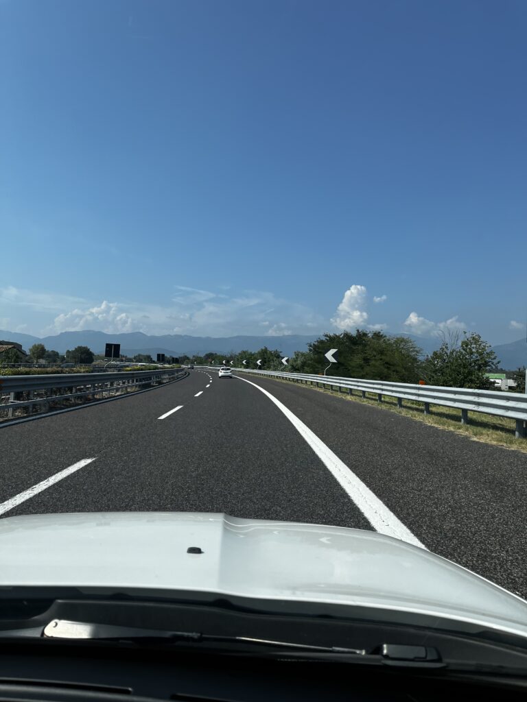 View of the highway out of car windshield | two week itinerary in northern Italy by train and car