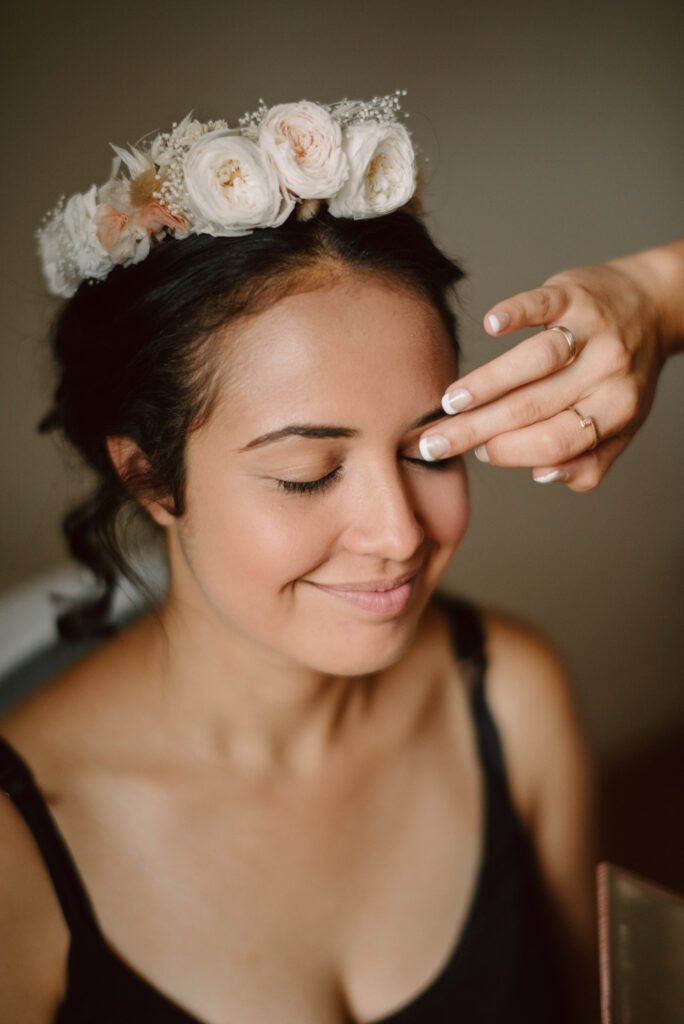 Makeup Artist applies makeup to brides eyelid using her fingertip