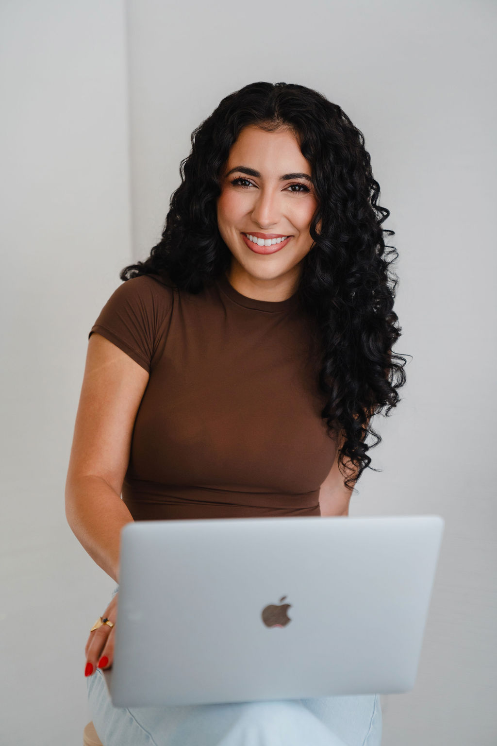 Color portrait of Sofia Brown smiling behind her laptop – blog manager and Pinterest strategist
